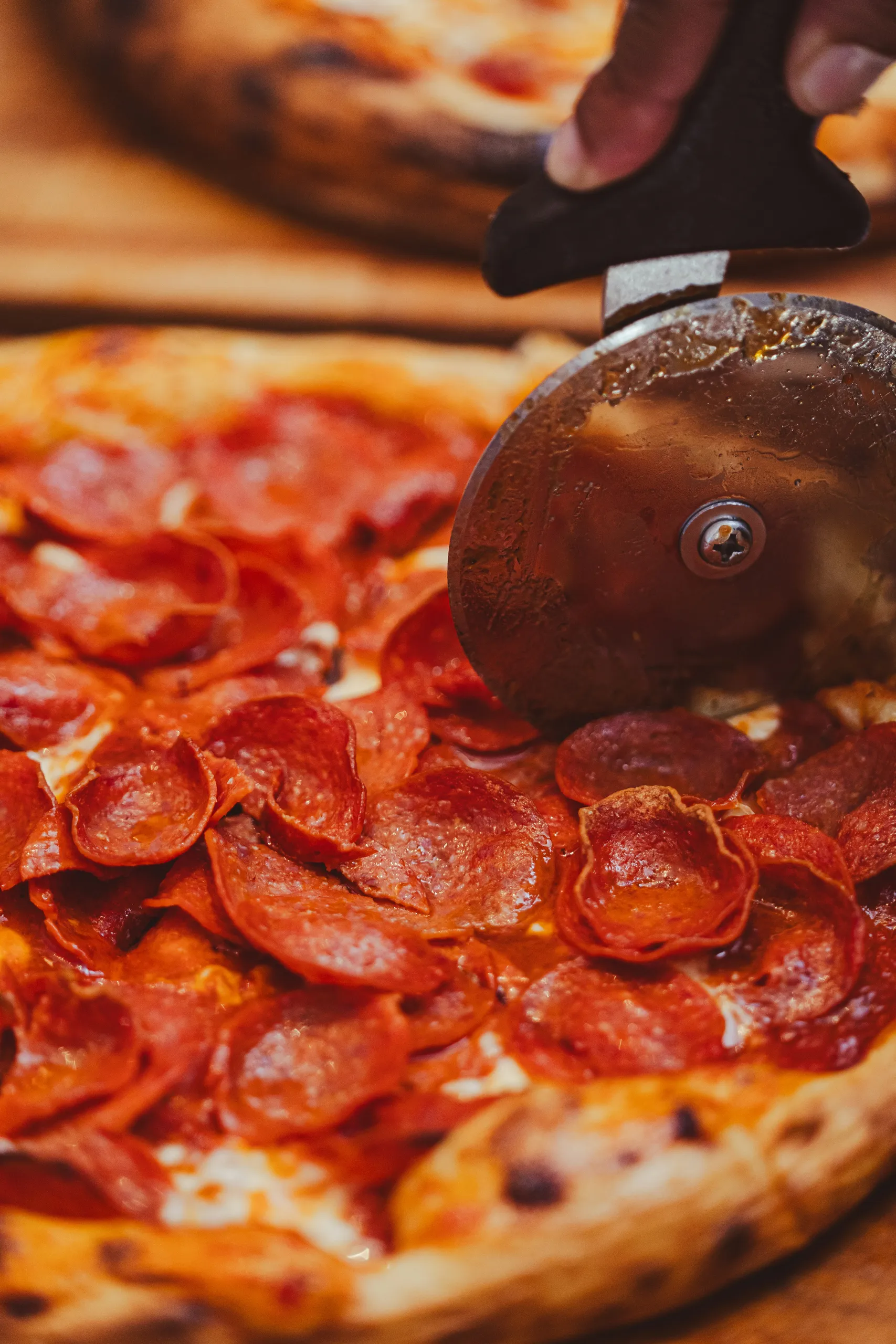 Cortando pizza pepperoni con cuchillo sobre la tabla