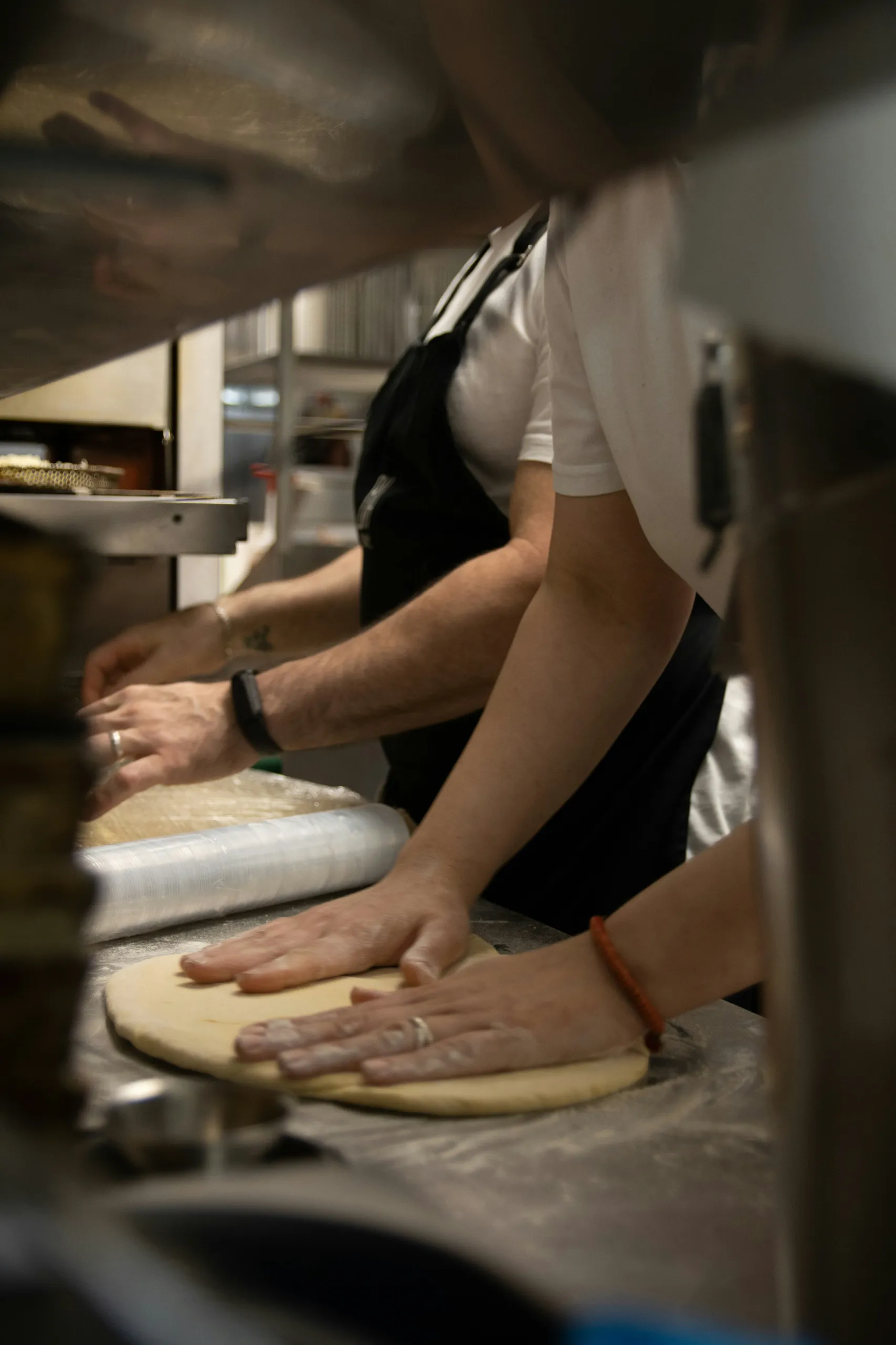 Manos amasando la masa de pizza sobre la encimera de la cocina